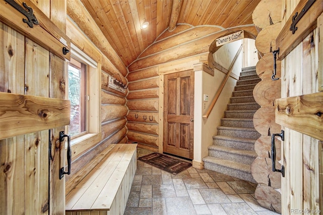 interior space featuring rustic walls, vaulted ceiling, and wooden ceiling