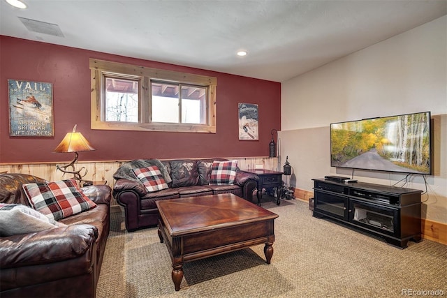 living room featuring carpet floors and wooden walls