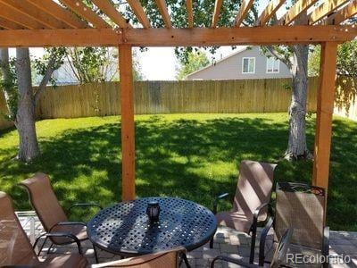 view of yard with a fenced backyard, outdoor dining space, a pergola, and a patio