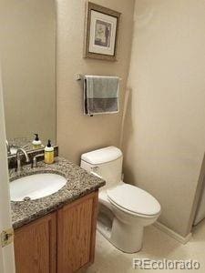 half bathroom featuring toilet and vanity