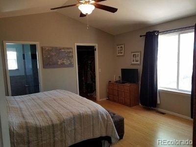 bedroom featuring baseboards, lofted ceiling, ceiling fan, and light wood-type flooring