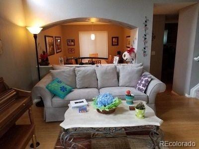 living room featuring arched walkways and wood finished floors