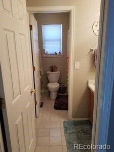 full bathroom with toilet, tile patterned flooring, and vanity