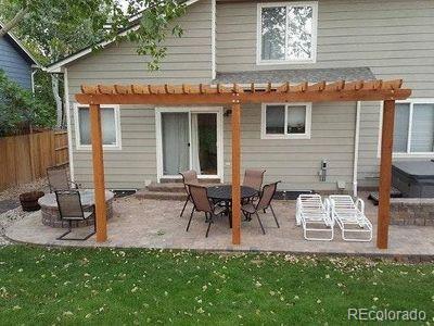 rear view of house with a patio, a pergola, fence, and a lawn