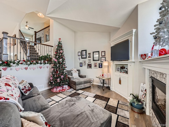 living room with ceiling fan, lofted ceiling, and wood-type flooring