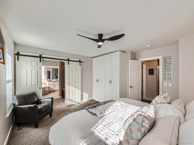 carpeted bedroom featuring a barn door, ceiling fan, and a closet