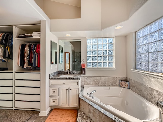 bathroom with tile patterned floors, vanity, separate shower and tub, and a wealth of natural light