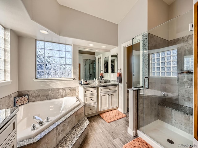 bathroom with vanity, wood-type flooring, and independent shower and bath