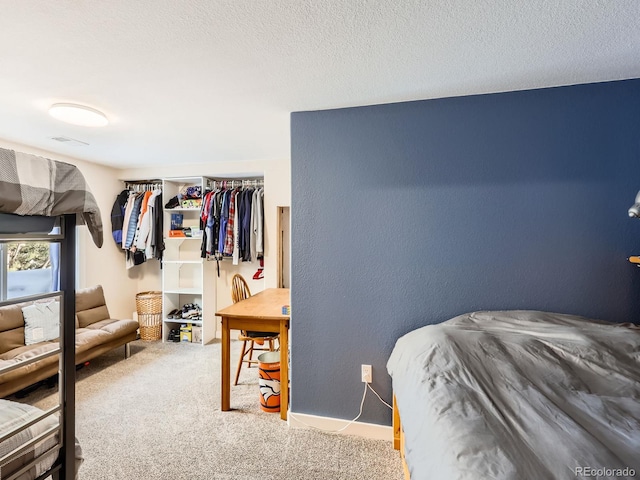 bedroom with light colored carpet and a textured ceiling