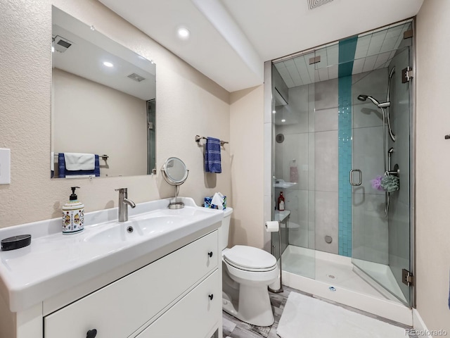 bathroom featuring vanity, toilet, and a shower with door