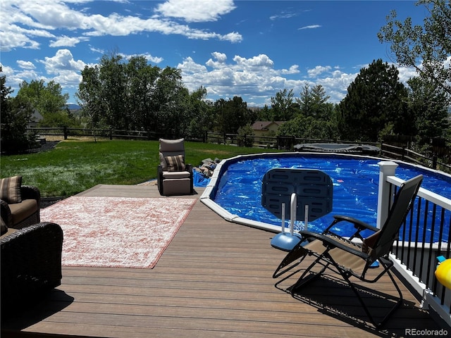 view of swimming pool featuring a wooden deck and a lawn