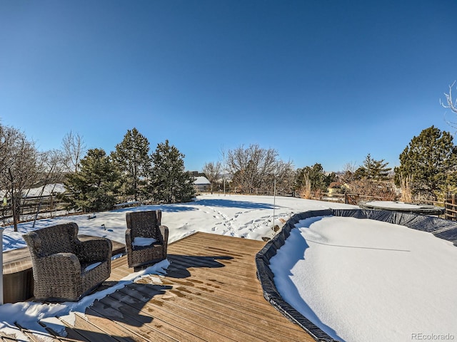 snow covered pool featuring a deck