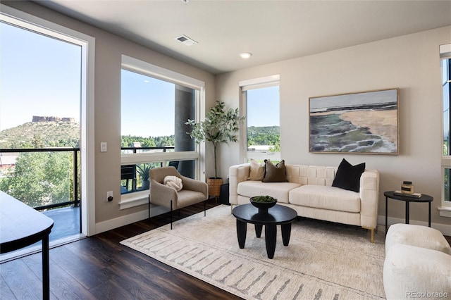 living room with baseboards, visible vents, dark wood finished floors, and recessed lighting