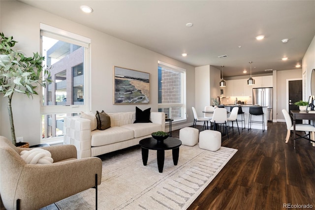 living area featuring dark wood-style floors, plenty of natural light, baseboards, and recessed lighting