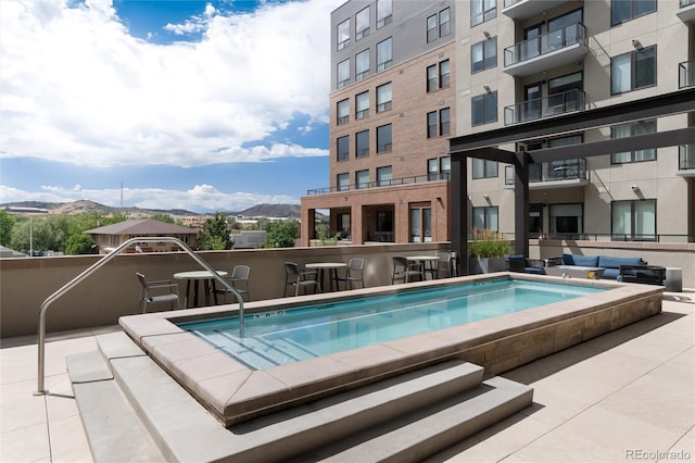 view of pool featuring exterior bar and a mountain view