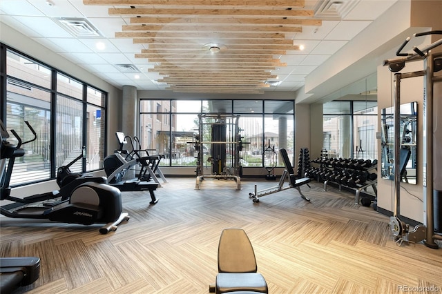 exercise room featuring carpet, visible vents, and a drop ceiling