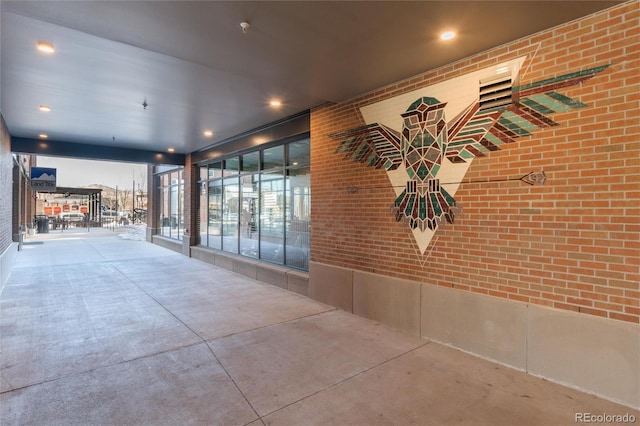 hall with brick wall and concrete flooring