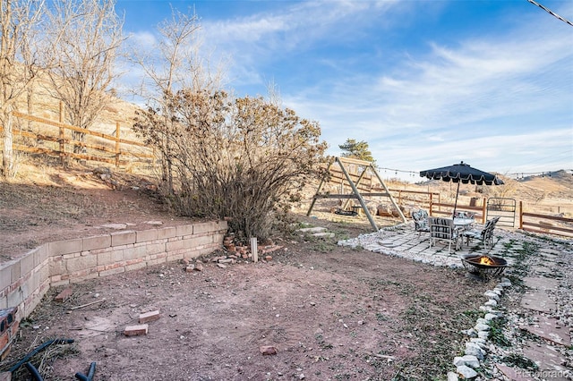 view of yard with fence, a playground, and a patio