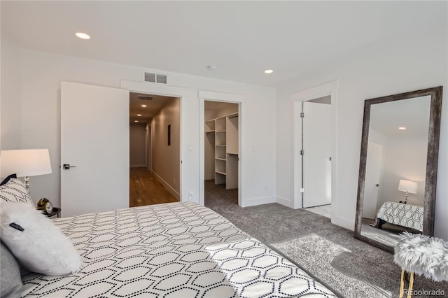 carpeted bedroom with a spacious closet and a closet