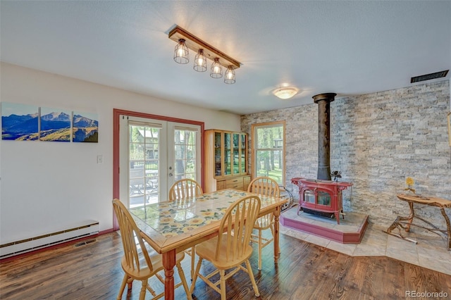 29250 County Road 330, Buena Vista, CO 81211 - dining space with a wood stove, a baseboard radiator, wood finished floors, and french doors
