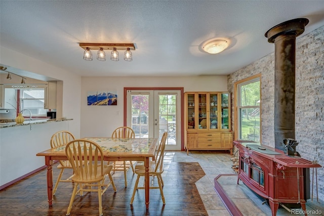 29250 County Road 330, Buena Vista, CO 81211 - dining room with a wood stove, french doors, wood finished floors, and a textured ceiling
