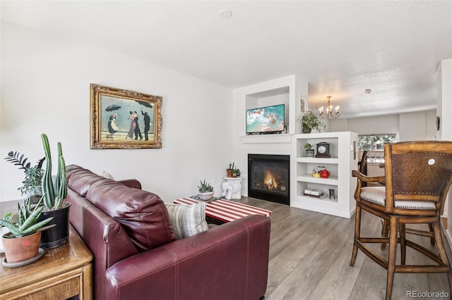 588 Beauprez Ave, Lafayette, CO 80026 - living room featuring wood finished floors, a glass covered fireplace, and a chandelier