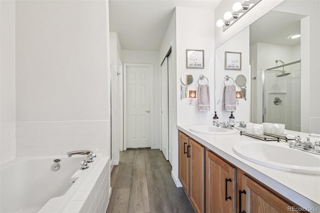 588 Beauprez Ave, Lafayette, CO 80026 - full bathroom featuring a stall shower, double vanity, a garden tub, and wood finished floors