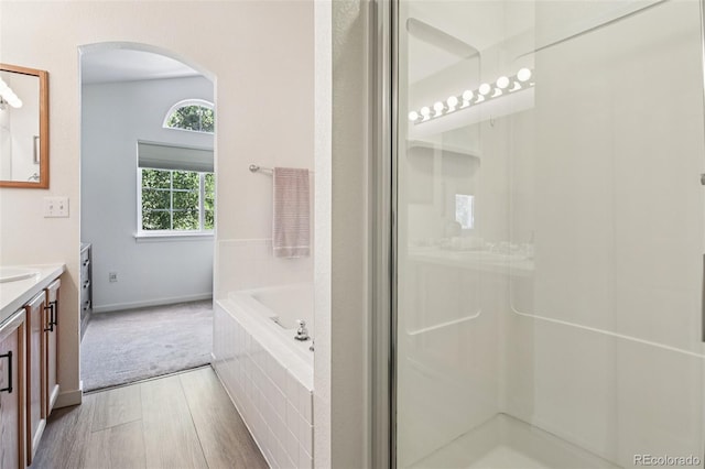 588 Beauprez Ave, Lafayette, CO 80026 - full bath featuring vanity, wood finished floors, a garden tub, and a shower