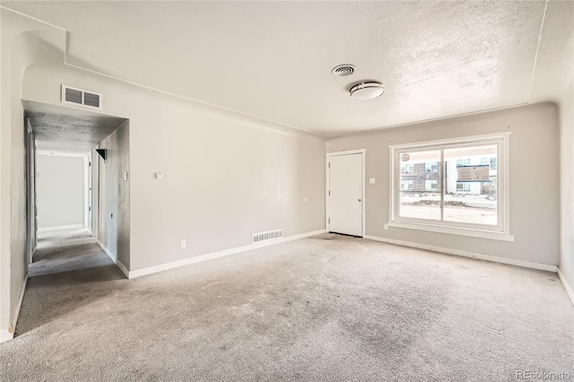 carpeted spare room featuring a textured ceiling