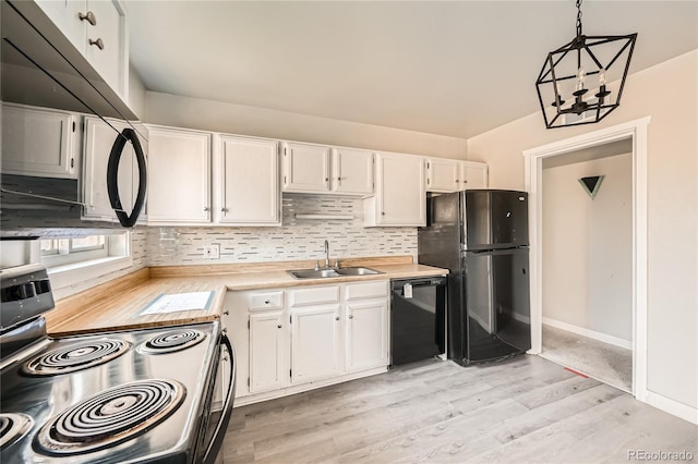 kitchen with white cabinets, pendant lighting, sink, and black appliances