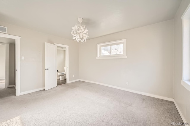 unfurnished bedroom featuring carpet, connected bathroom, and a notable chandelier