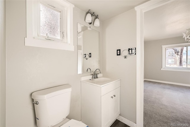 bathroom featuring a wealth of natural light, vanity, and toilet