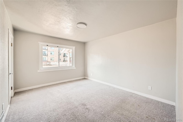 carpeted empty room featuring a textured ceiling