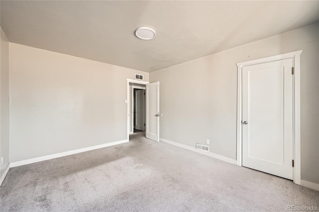 unfurnished room featuring light carpet