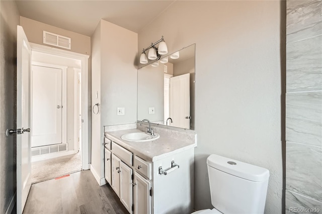 bathroom featuring vanity, wood-type flooring, and toilet