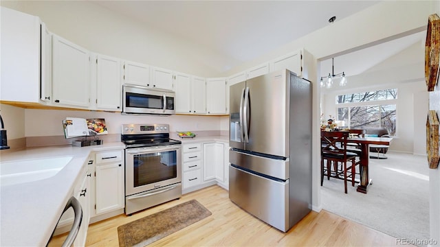 kitchen with white cabinetry, stainless steel appliances, and light hardwood / wood-style floors