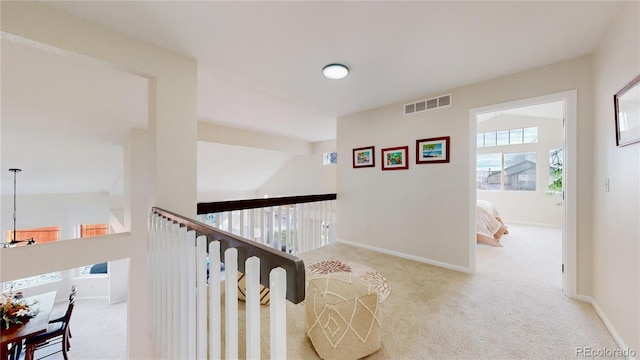 hallway featuring light carpet and vaulted ceiling with beams