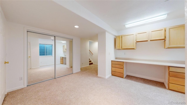 unfurnished office featuring light carpet and built in desk