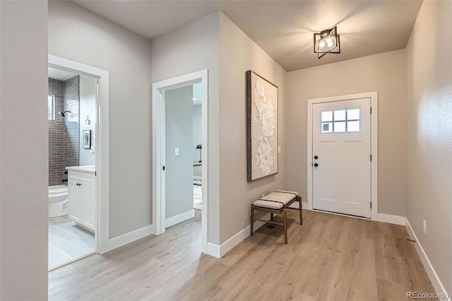 entrance foyer with light wood-style floors and baseboards