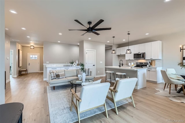 living room with light wood-style floors, baseboards, and recessed lighting