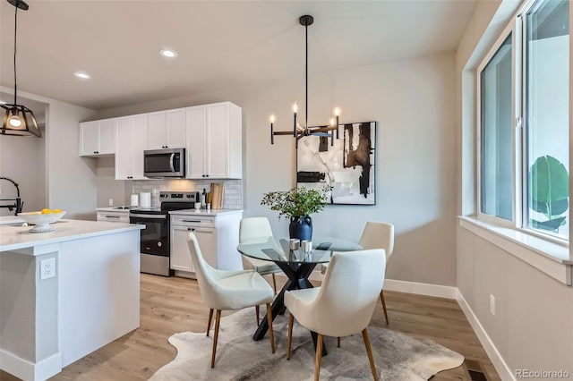 kitchen featuring white cabinets, stainless steel appliances, and light wood-type flooring