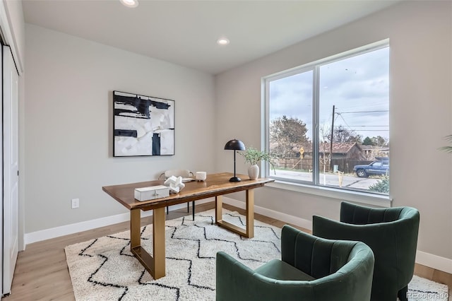 home office featuring baseboards, light wood-type flooring, and a wealth of natural light