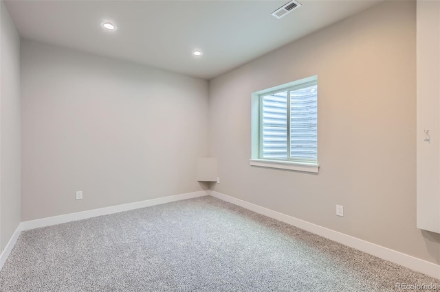 carpeted spare room featuring recessed lighting, baseboards, and visible vents