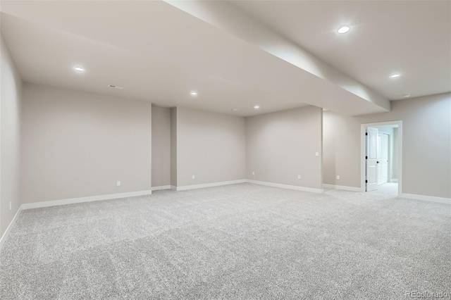 finished below grade area with baseboards, light carpet, and recessed lighting