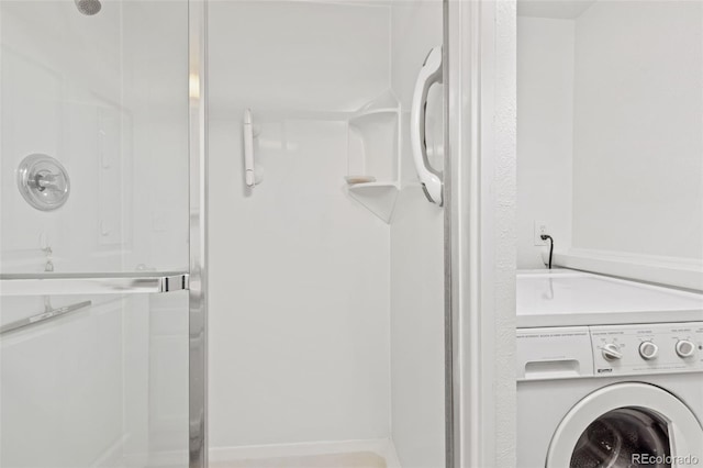 full bathroom featuring washer / clothes dryer and a stall shower