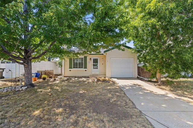 view of front of home featuring an attached garage, fence, and concrete driveway