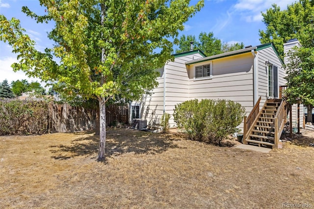 view of home's exterior with stairs and fence