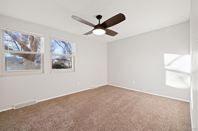 unfurnished room with ceiling fan and carpet