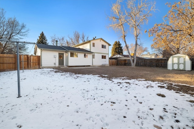 snow covered house with a storage unit