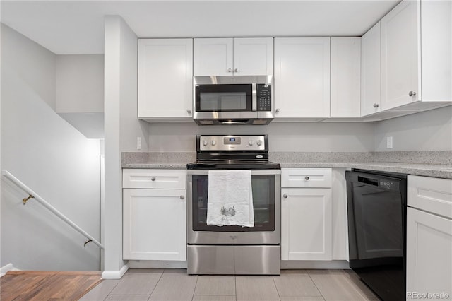 kitchen featuring white cabinetry, light stone countertops, and appliances with stainless steel finishes